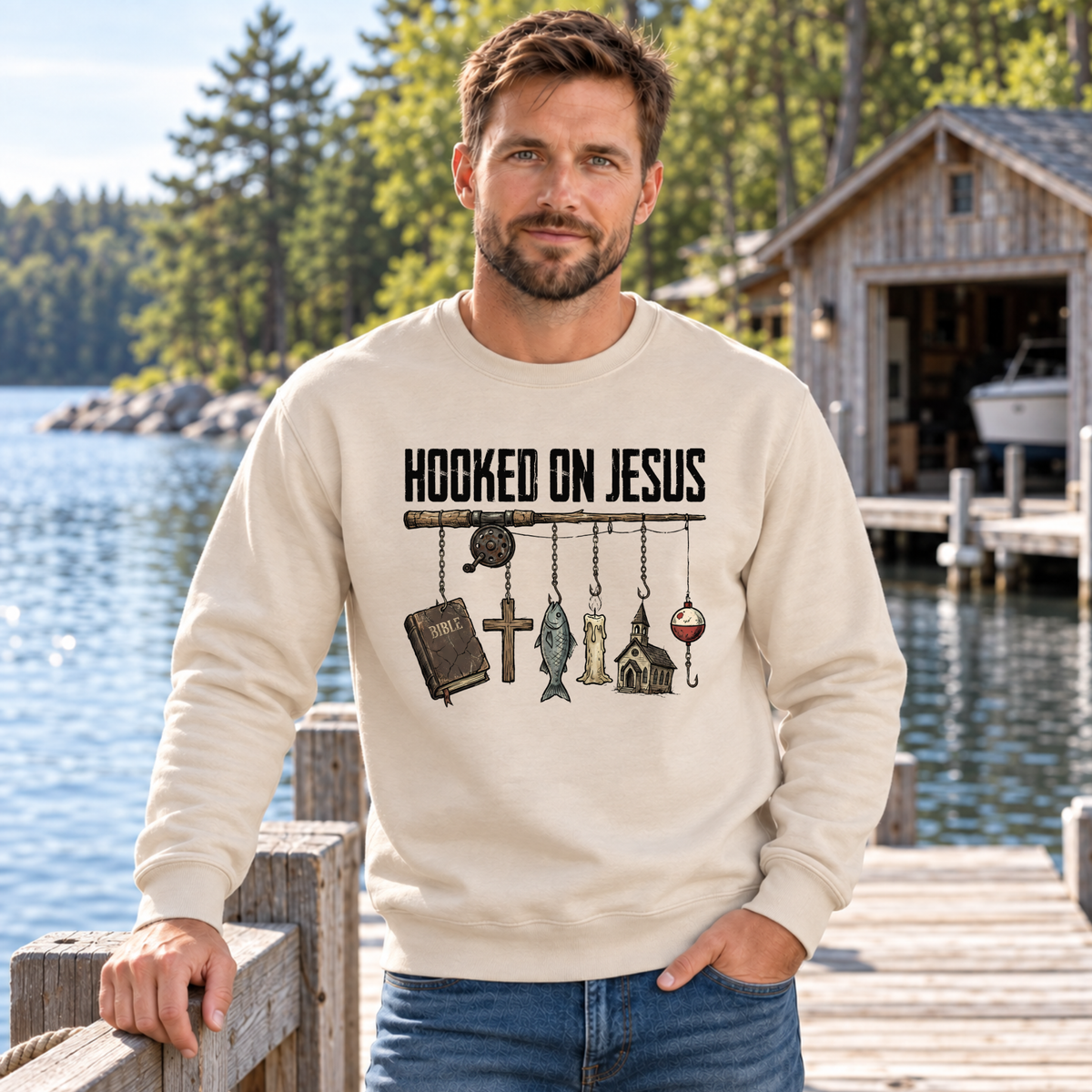 Man wearing a sand Hooked on Jesus sweatshirt on a lakeside dock.