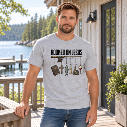 Man wearing a sports gray Hooked on Jesus T-shirt on a lakeside cabin deck.
