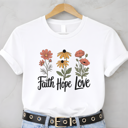 White t-shirt with floral design and 'Faith Hope Love' text on a hanger.