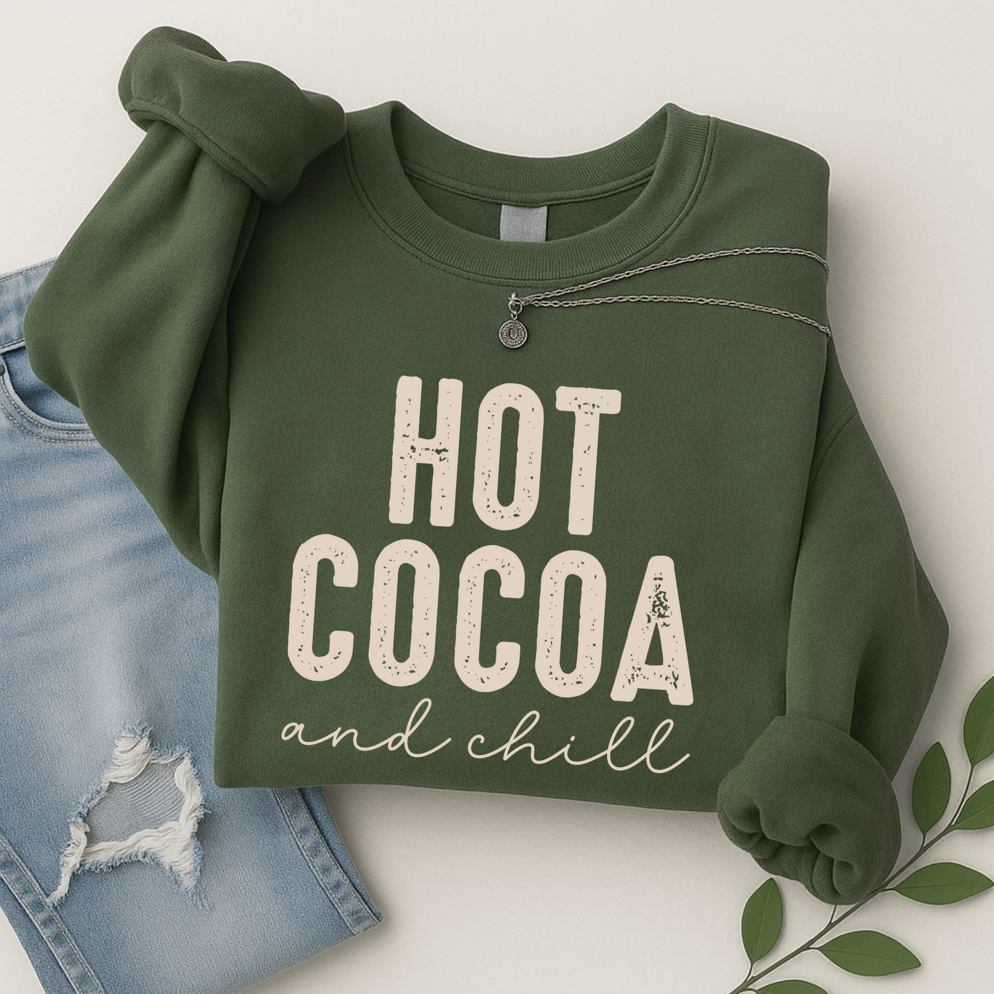 Hot Cocoa and Chill sweatshirt in green – cozy flat lay with jeans