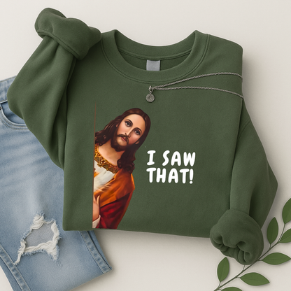 Green sweatshirt with a graphic of a Jesus saying 'I SAW THAT!' text, paired with jeans and leaves on a light background.