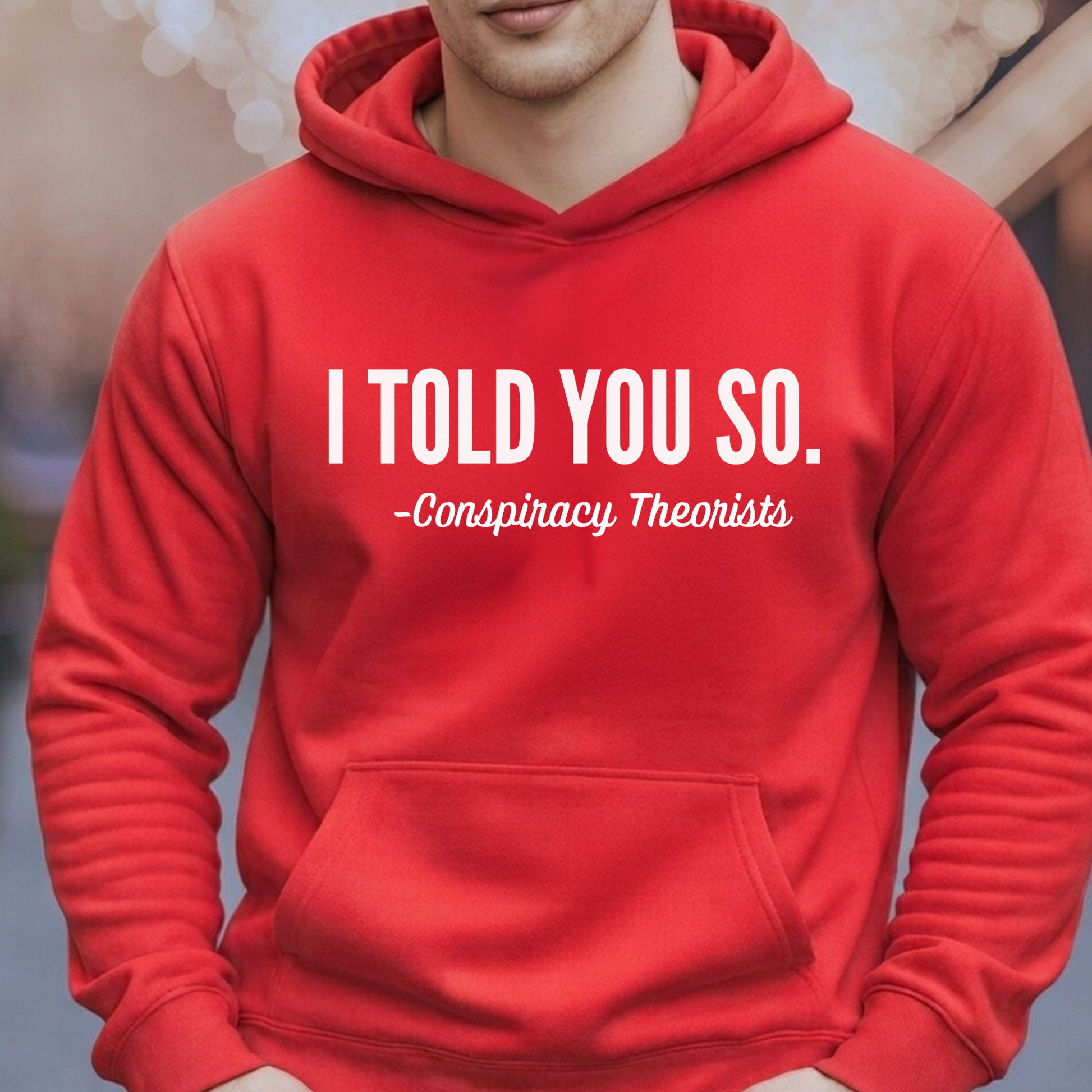 Man wearing red pullover hoodie with white “I Told You So – Conspiracy Theorists” print