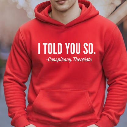 Man wearing red pullover hoodie with white “I Told You So – Conspiracy Theorists” print
