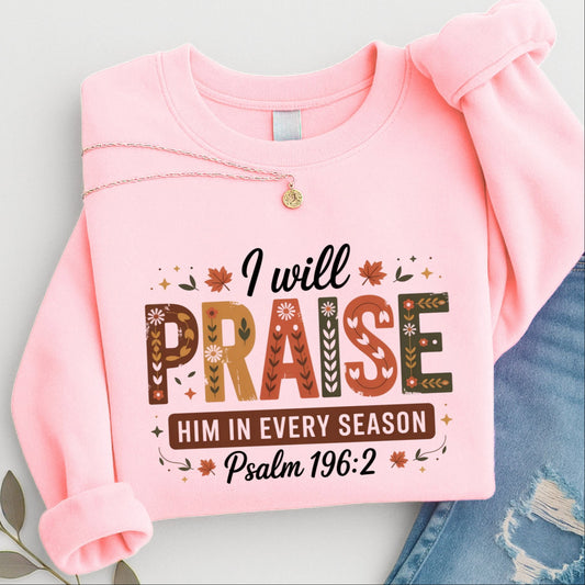  Folded pink “I Will Praise Him In Every Season” sweatshirt with fall floral lettering and Bible verse quote
