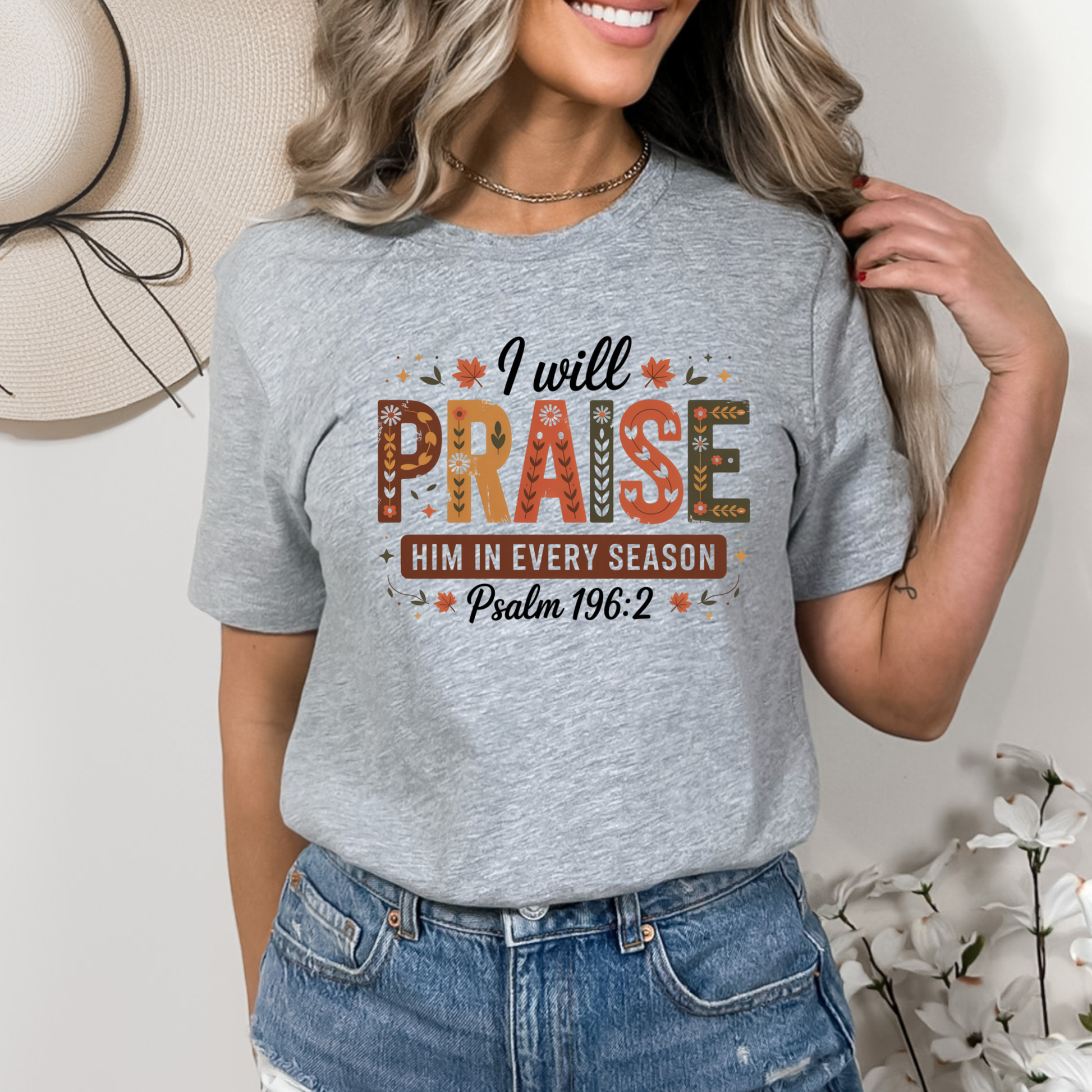 Woman in gray “I Will Praise Him In Every Season” fall faith shirt with rustic background
