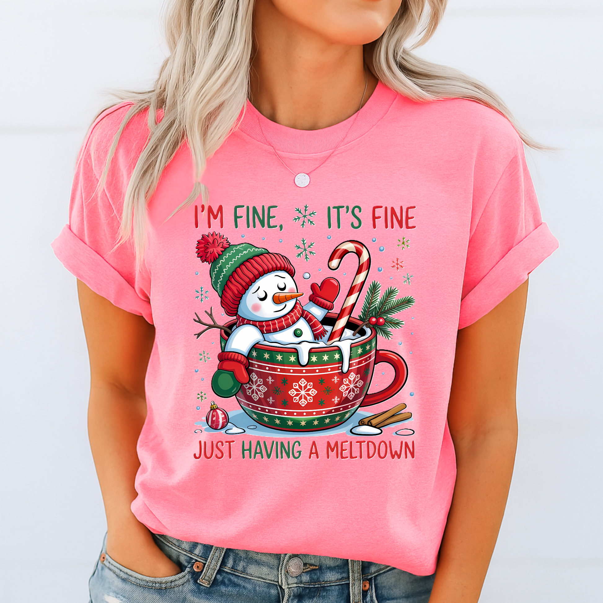 Woman wearing bright pink Christmas tee with festive snowman design.