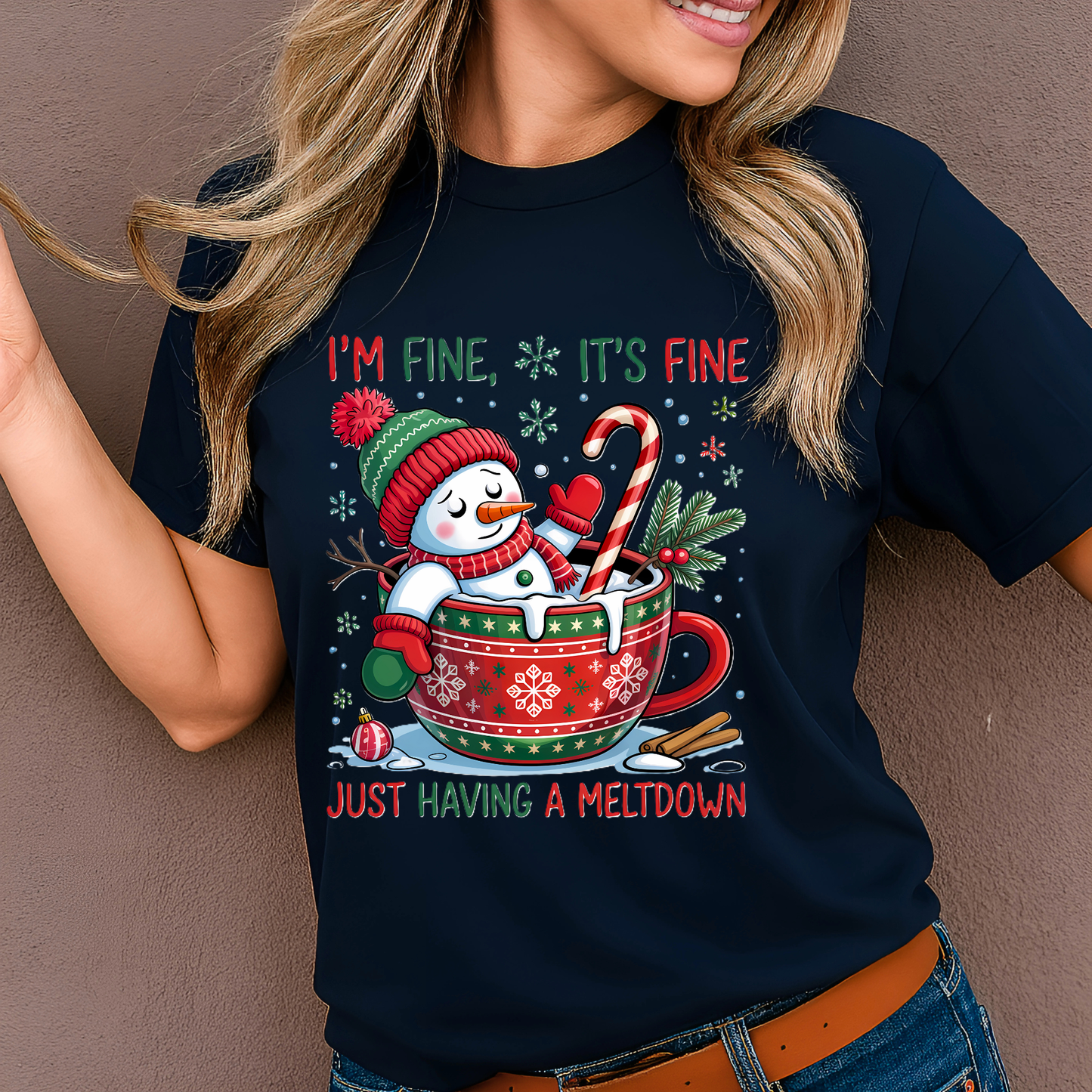 Woman in navy blue holiday tee with snowman in cocoa mug Christmas design.