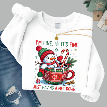 Flat lay of white snowman sweatshirt styled with denim and gift boxes