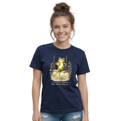 Woman modeling a navy T-shirt with a frog sitting on a swing holding a mug and the words “I could be meaner but Jesus said no.”