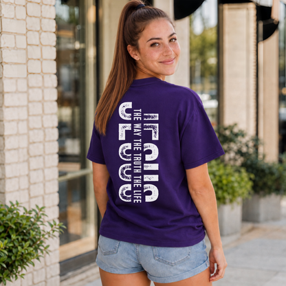 Woman shown from behind wearing a purple T-shirt with vertical white JESUS lettering and “The Way, The Truth, The Life” text.