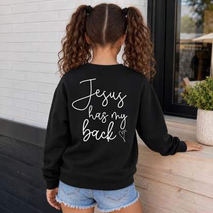 Back view of a girl wearing a black youth sweatshirt with Jesus Has My Back script lettering and a heart cross graphic.