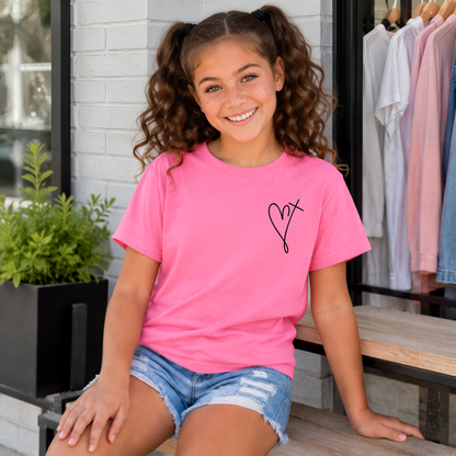 Girl wearing a Bright Pink youth T-shirt with a small heart cross graphic on the front chest.