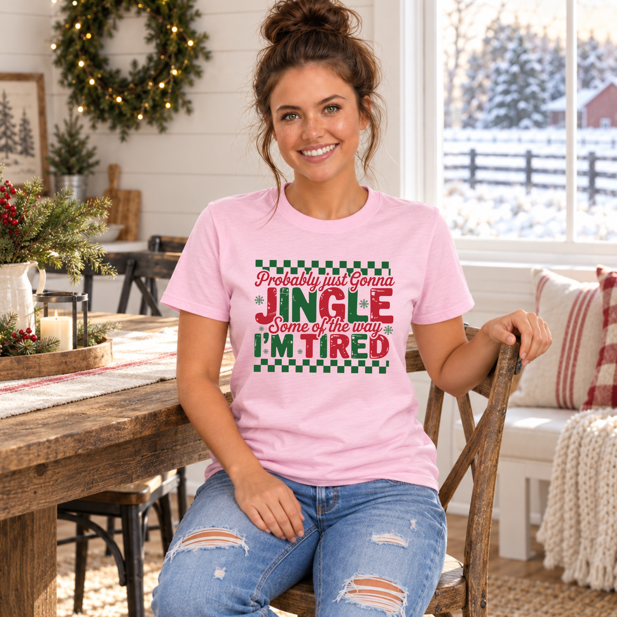 Woman wearing a light pink T-shirt with red and green Probably Just Gonna Jingle Some of the Way I'm Tired Christmas design indoors