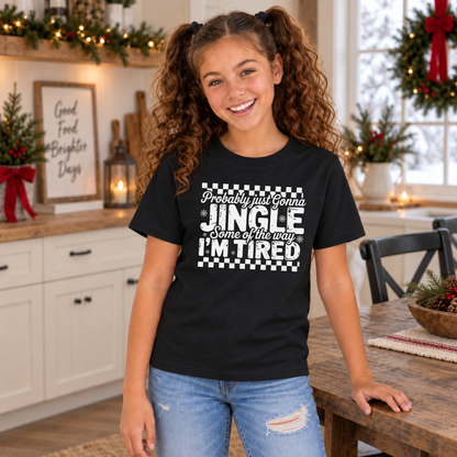 Girl wearing a black youth T-shirt with white Probably Just Gonna Jingle Some of the Way I'm Tired Christmas design in a holiday kitchen