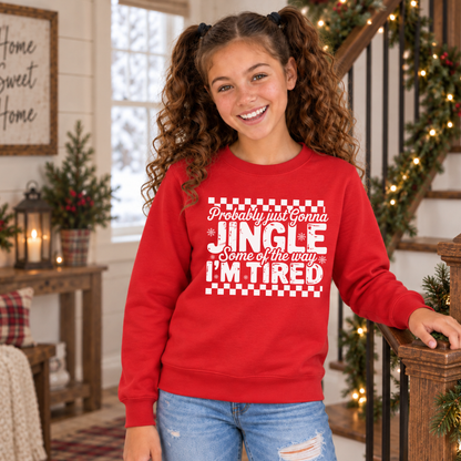 Girl wearing a red youth sweatshirt with white Probably Just Gonna Jingle Some of the Way I'm Tired Christmas design by a decorated staircase