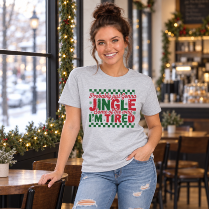 Woman wearing a sport gray T-shirt with red and green Probably Just Gonna Jingle Some of the Way I'm Tired Christmas design in a café