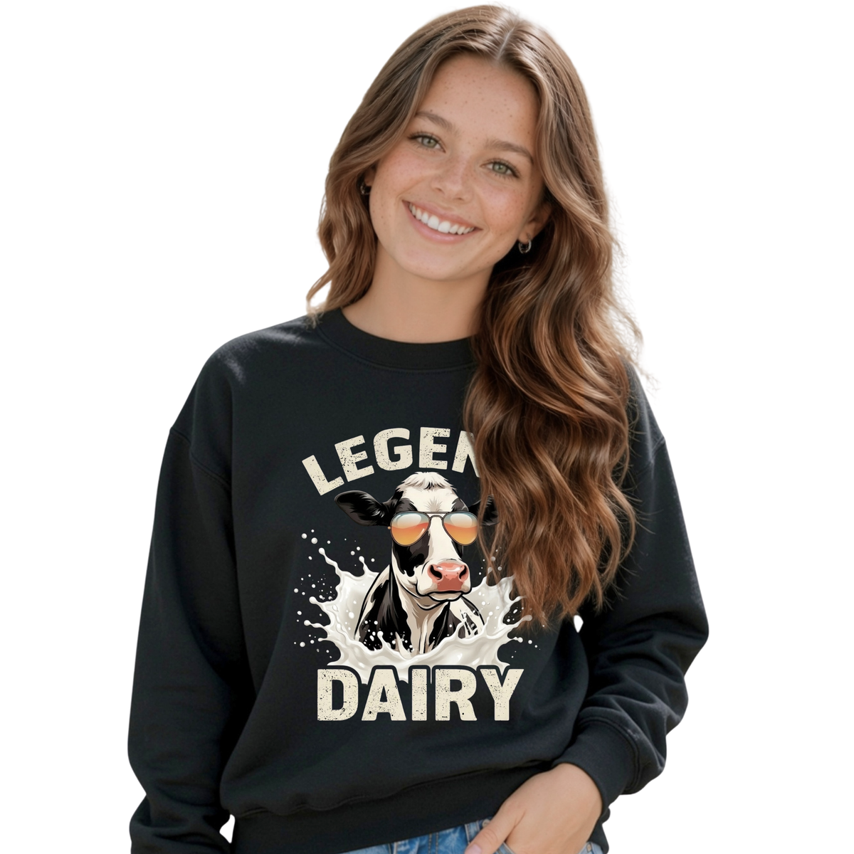 A smiling young girl wears a black crewneck sweatshirt with a “LEGEND DAIRY” graphic showing a black-and-white cow in sunglasses splashing through milk, against a white background.