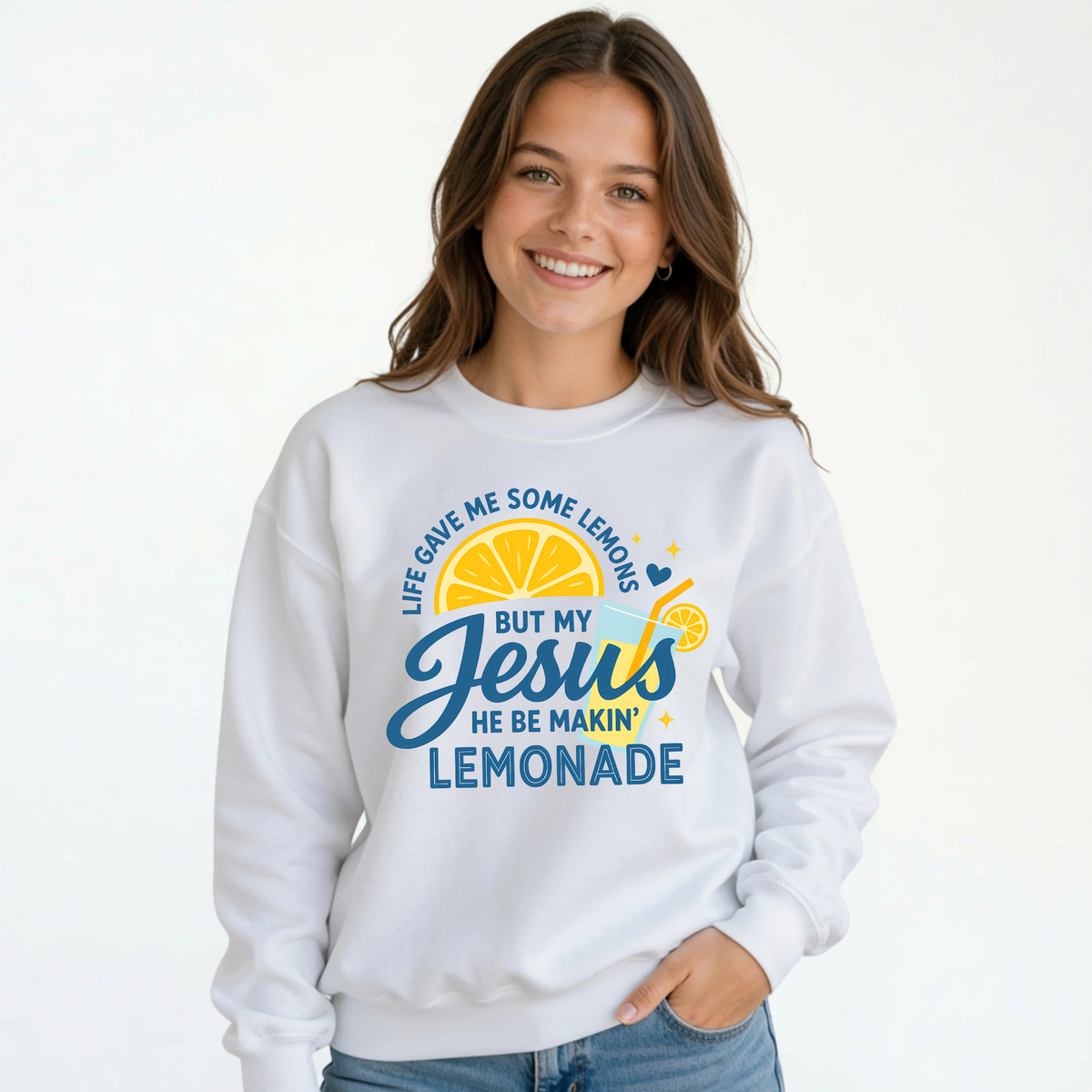 Youth girl wearing a white crewneck sweatshirt with the Jesus Be Makin’ Lemonade lemon and lemonade faith design.