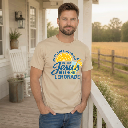 Man wearing a sand T-shirt with the Jesus Be Makin’ Lemonade lemon and drink design in blue and yellow on a farmhouse porch.