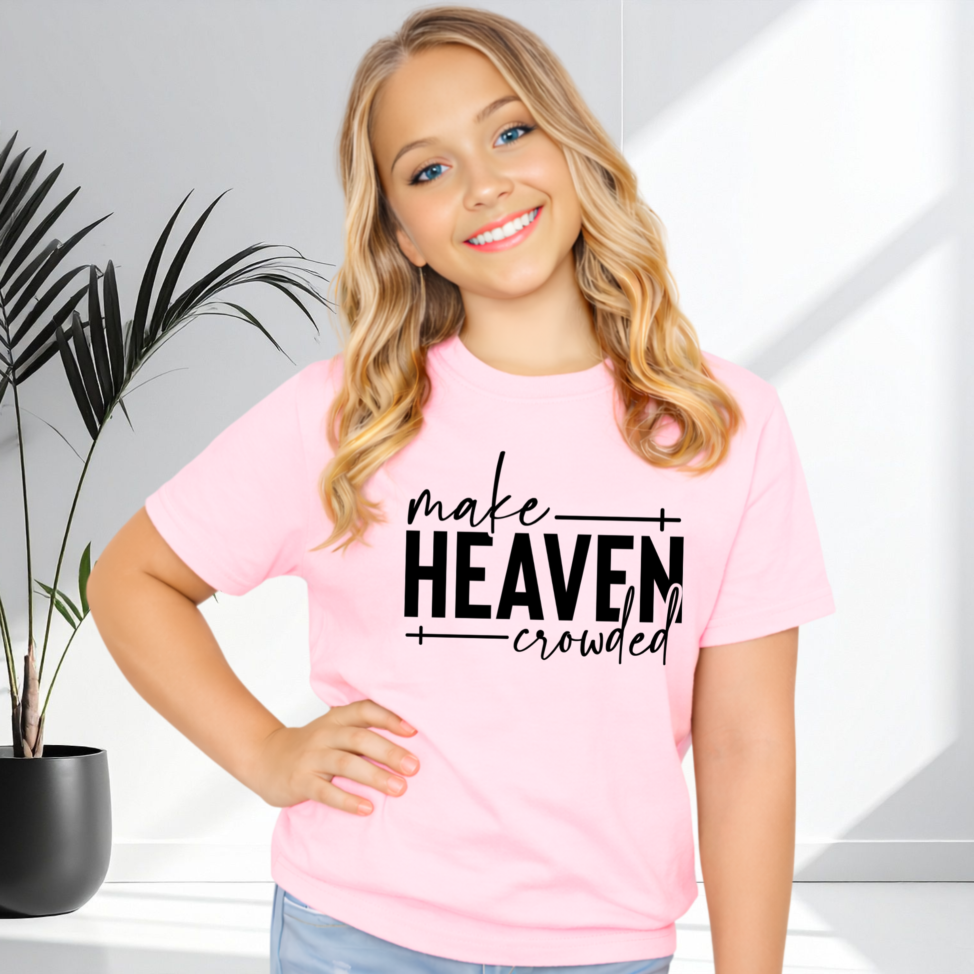Girl wearing light pink Make Heaven Crowded t-shirt smiling and posing