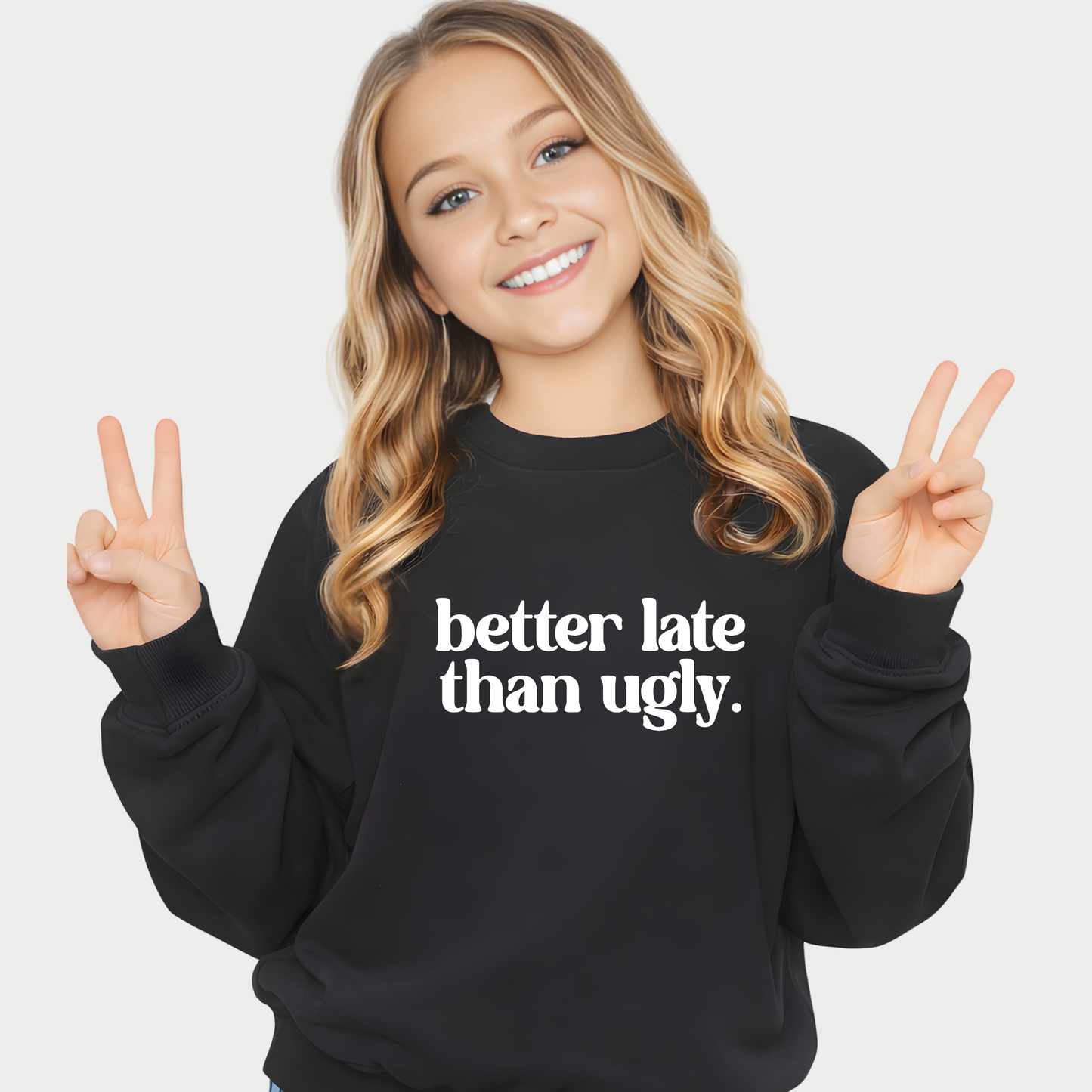 Girl wearing black Better Late Than Ugly youth sweatshirt giving peace sign