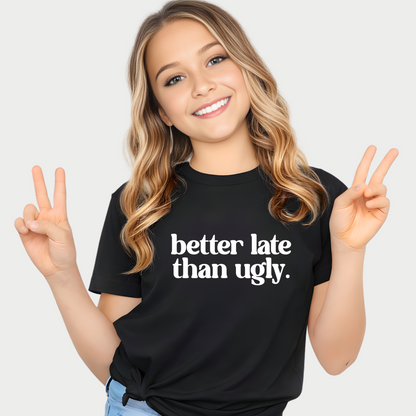 Smiling girl wearing black Better Late Than Ugly youth t-shirt giving peace sign