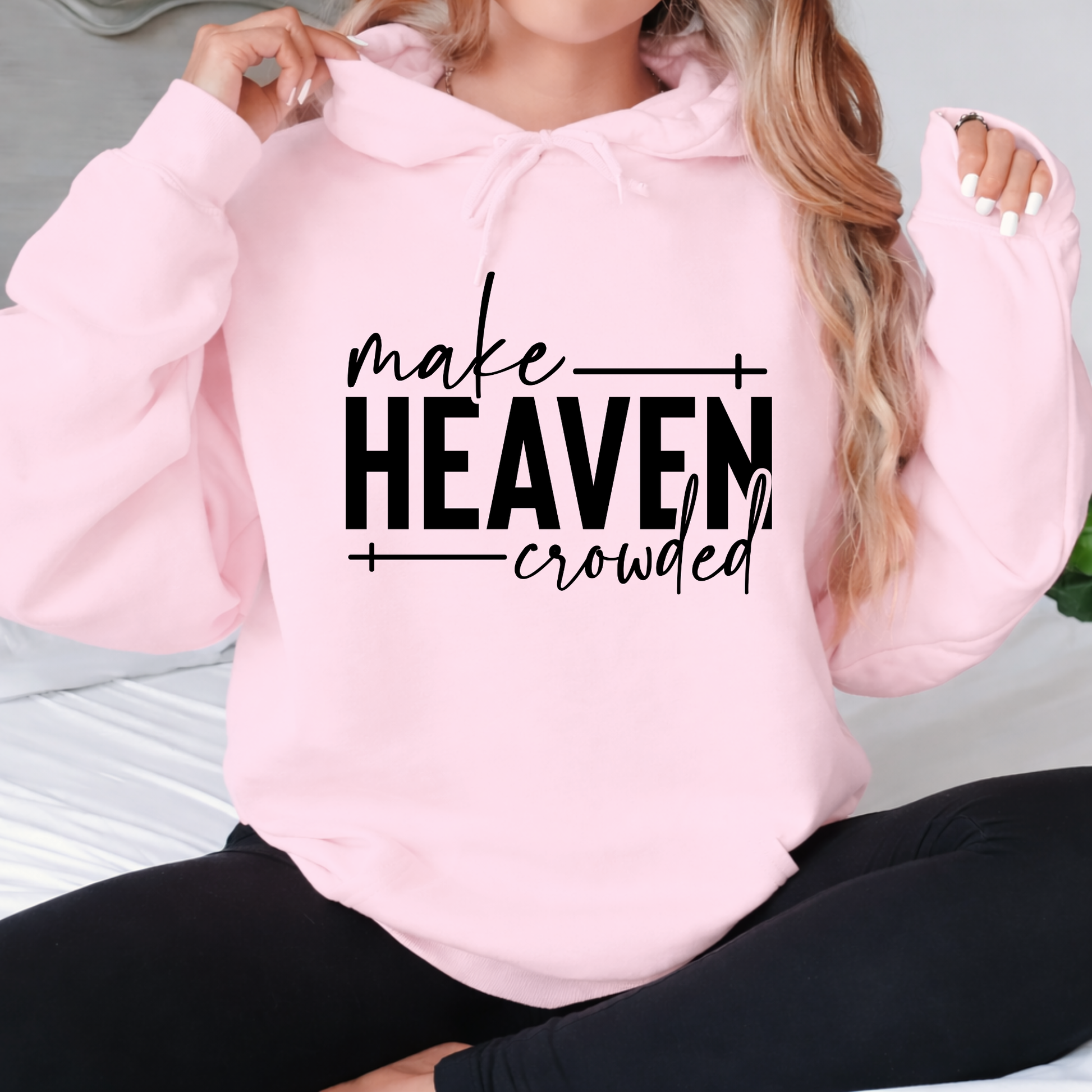 Make Heaven Crowded design on pink sweatshirt worn by woman sitting