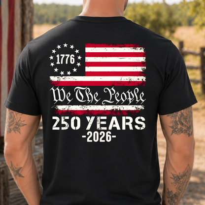 Man wearing a black America 250 t-shirt with a patriotic design and American flag, standing outdoors.