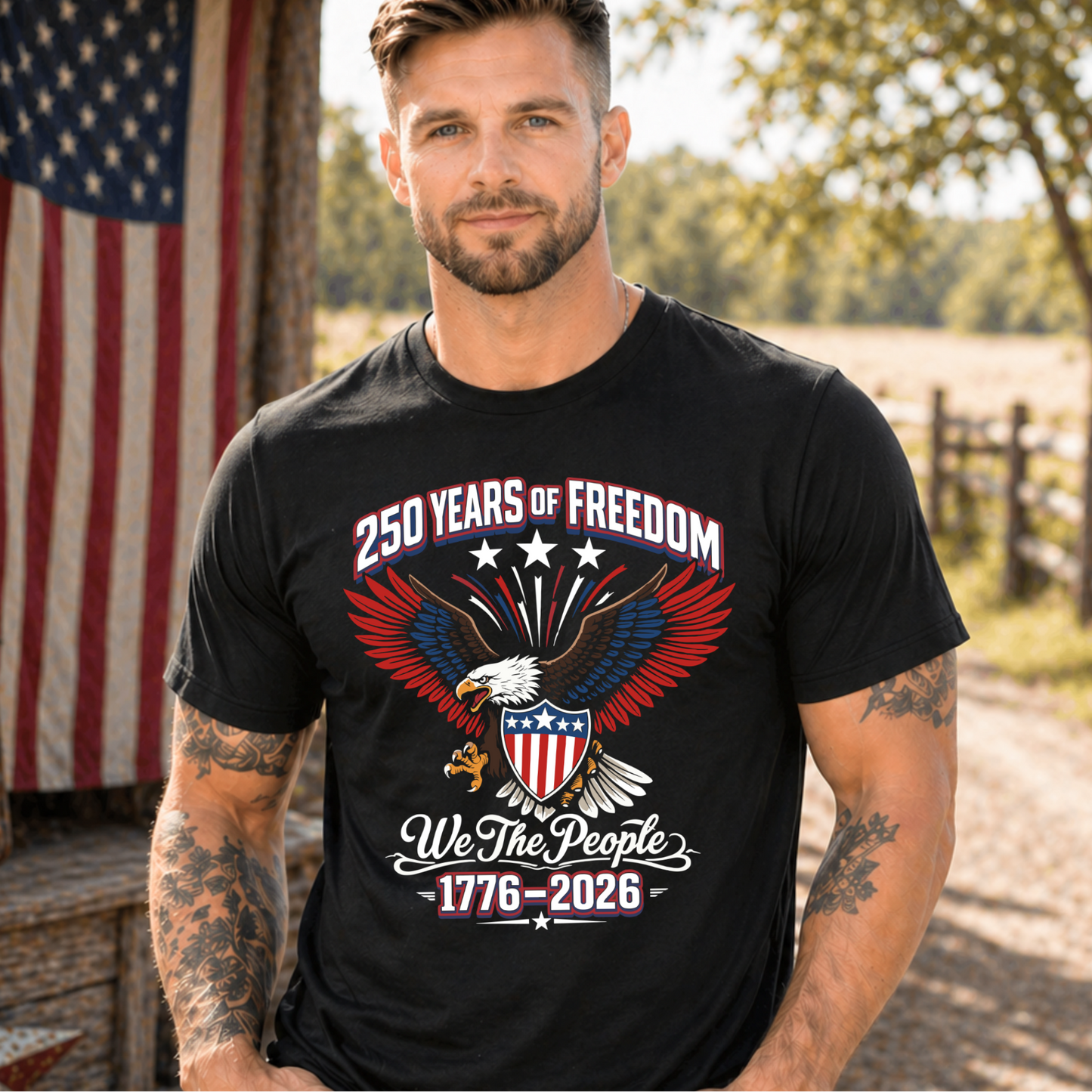 Man wearing a black t-shirt with a patriotic design featuring an eagle and American flag, standing outdoors with an American flag in the background.