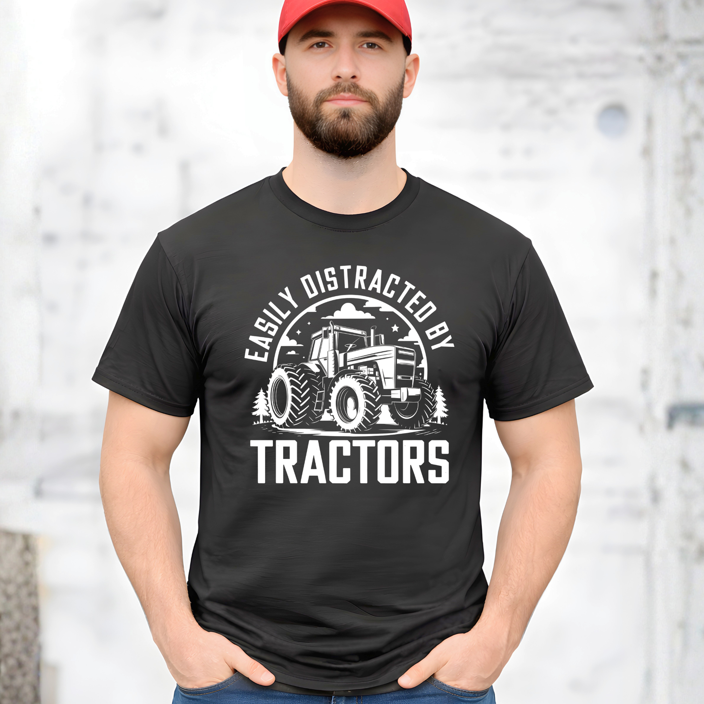Man wearing a black t-shirt with a tractor graphic and text, standing against a light background