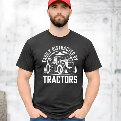 Man wearing a black t-shirt with a tractor graphic and text, standing against a light background