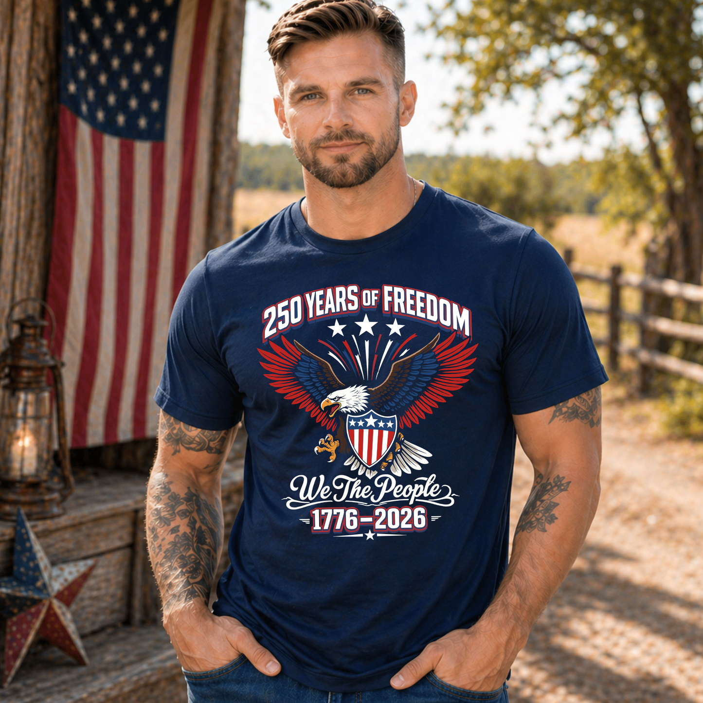 Man wearing a navy blue America 250 t-shirt with an eagle and text design, standing outdoors with an American flag in the background.