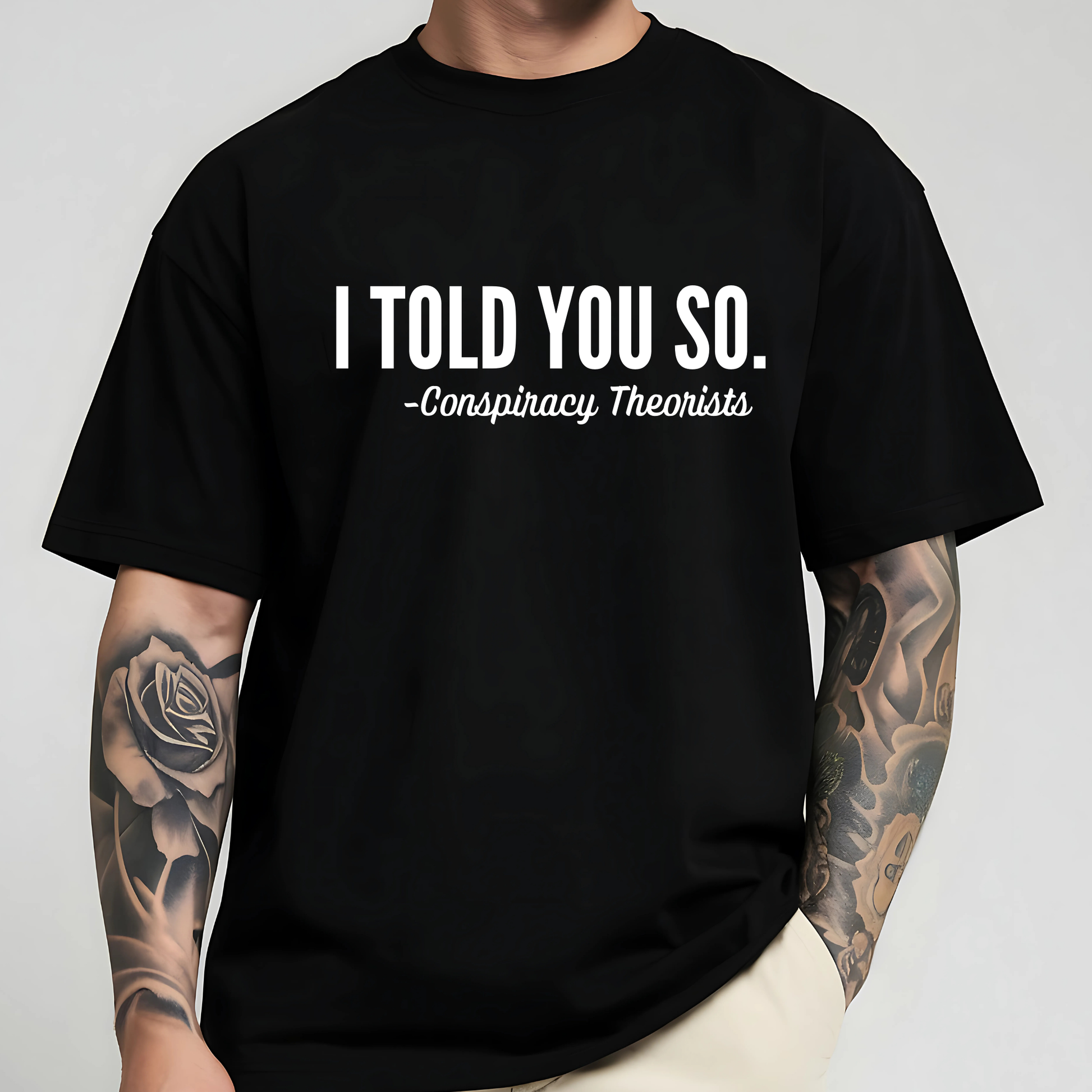 Man wearing black “I Told You So - Conspiracy Theorists” tee