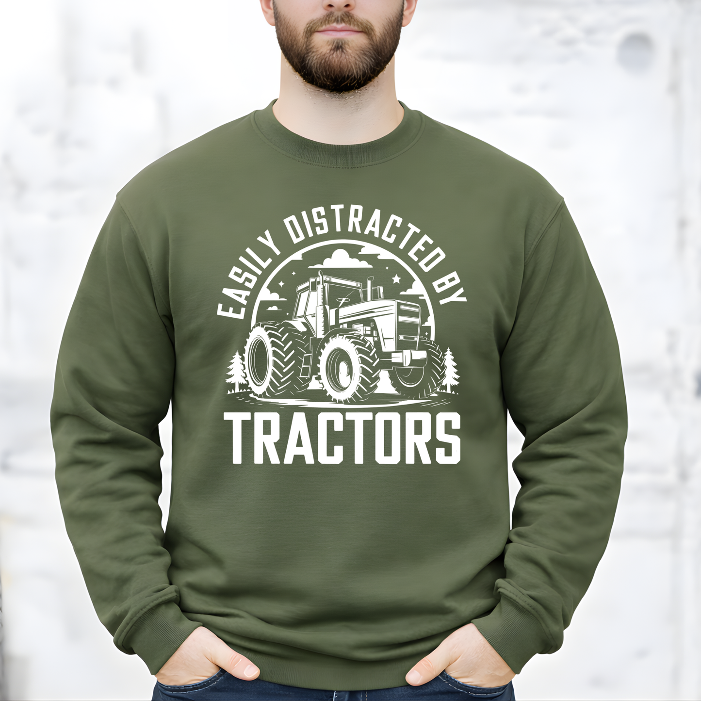 Man wearing military green Easily Distracted by Tractors sweatshirt