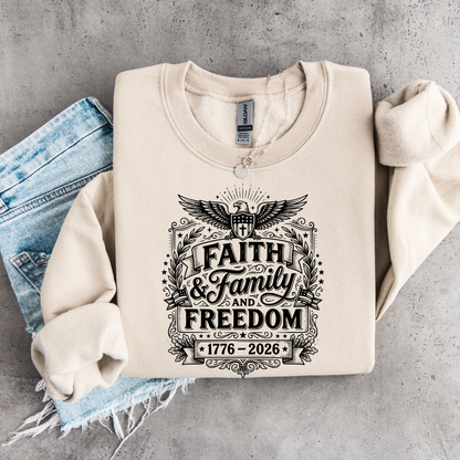 Beige sweatshirt with 'Faith & Family and Freedom 1776-2026' text on a concrete surface.