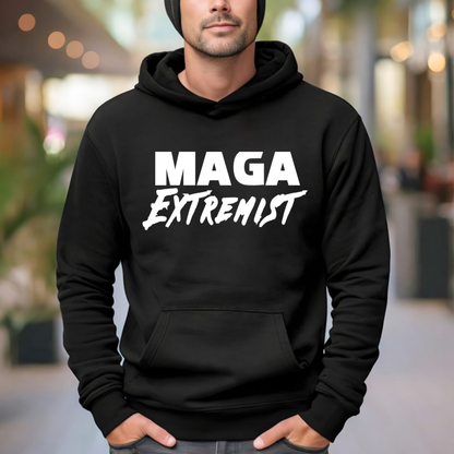 Person wearing a black hoodie with 'MAGA Extremist' text in a blurred outdoor setting