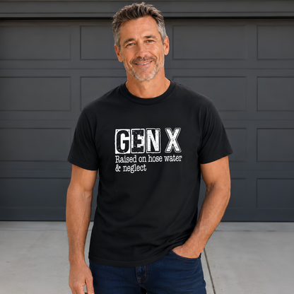 Man wearing a black Gen X T-shirt with distressed “Raised on hose water & neglect” lettering in front of a dark garage door.