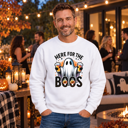 Man wearing a white crewneck sweatshirt with the Here For The Boos beer ghost graphic at an outdoor Halloween party.