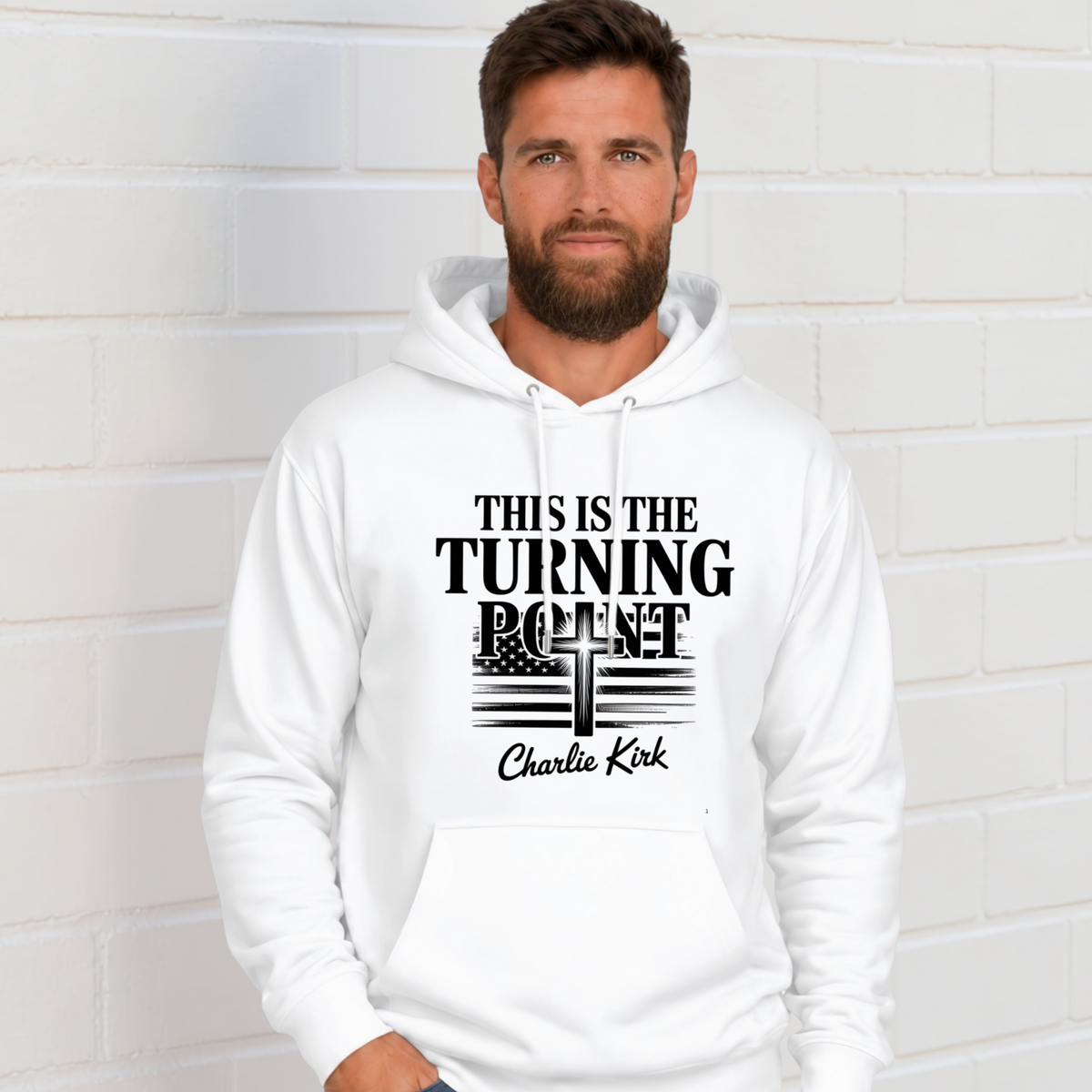 Man wearing a white hoodie with black This Is the Turning Point lettering, cross, American flag, and Charlie Kirk signature graphic.