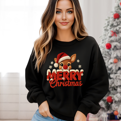 Woman wearing a black Christmas-themed sweatshirt with a reindeer and 'Merry Christmas' text, standing in front of a decorated Christmas tree.