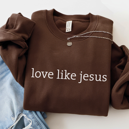 Flat lay navy blue sweatshirt with “love like jesus” white text design and silver necklace detail