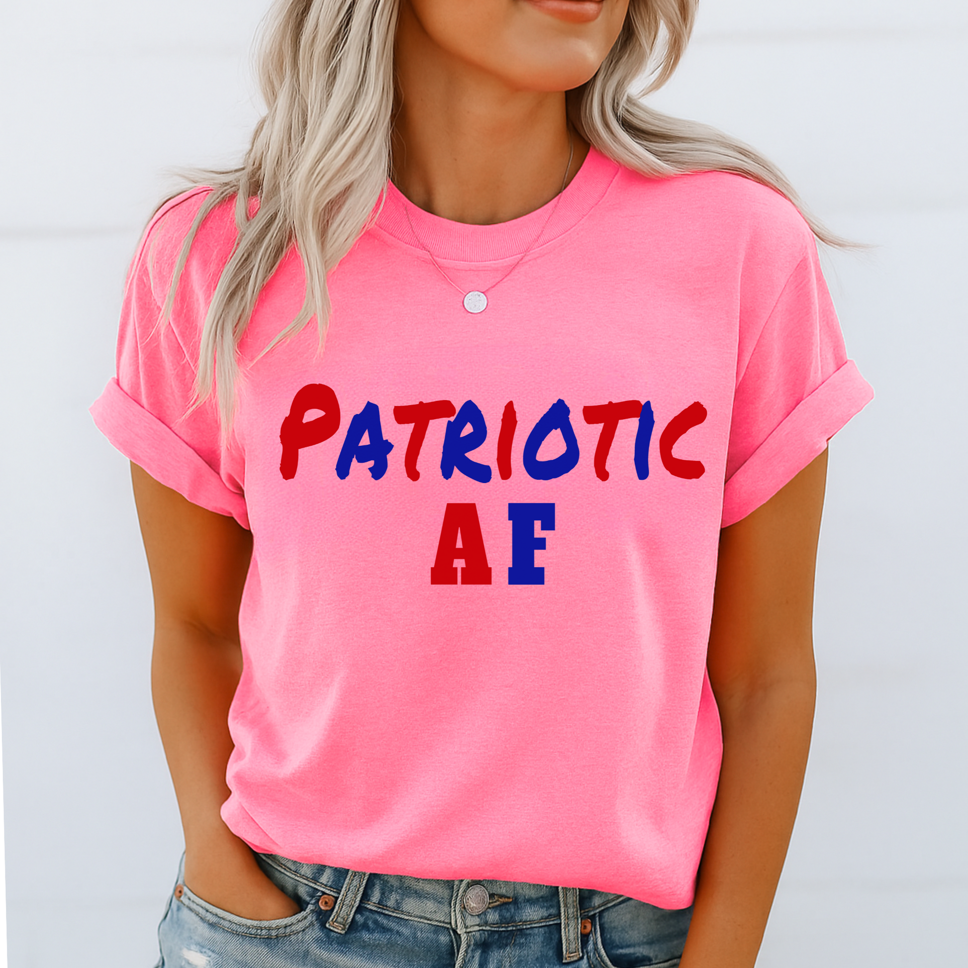 Model in bright safety pink “Patriotic AF” tee, styled casually with denim