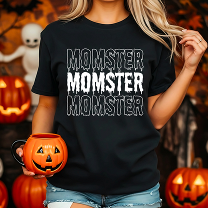 A Mom wearing a black t-shirt with 'MOMSTER' text, holding a pumpkin mug in a Halloween-themed setting.