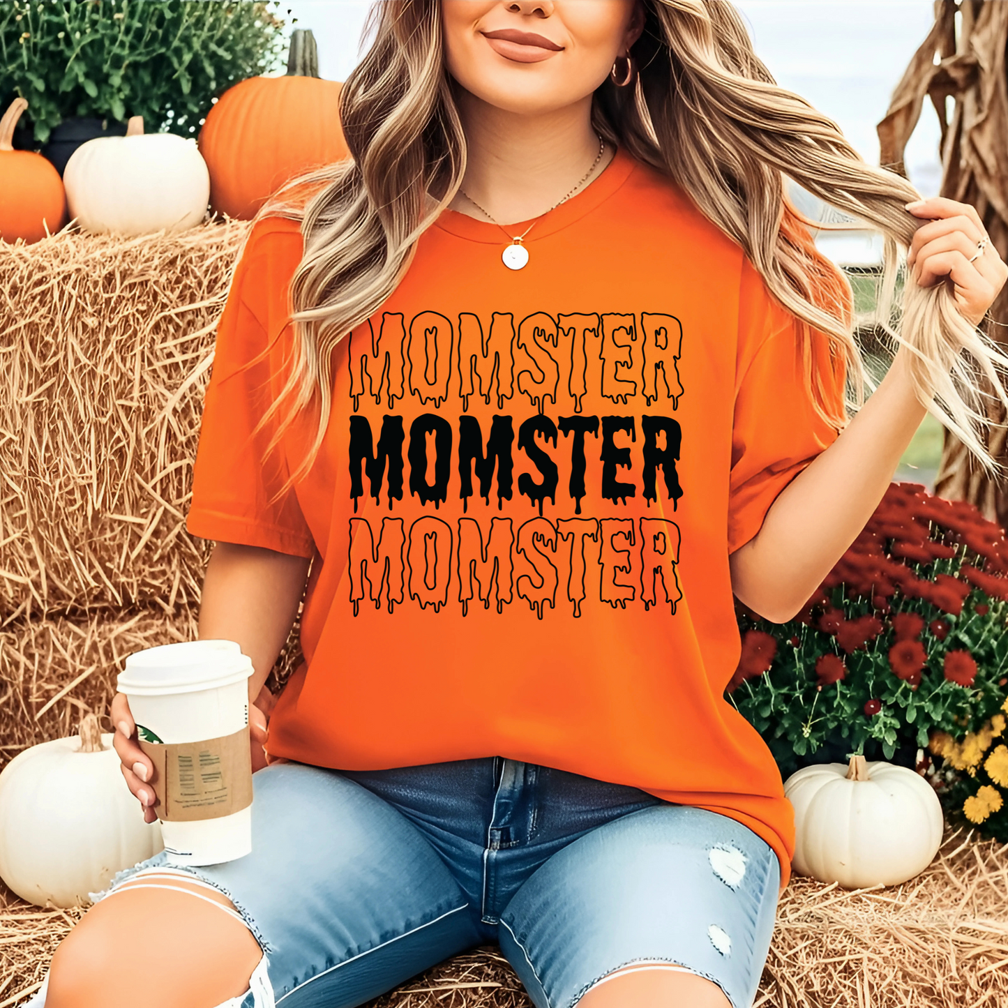 Woman wearing an Funny  orange Halloween 'MOMSTER' shirt in a pumpkin patch setting.