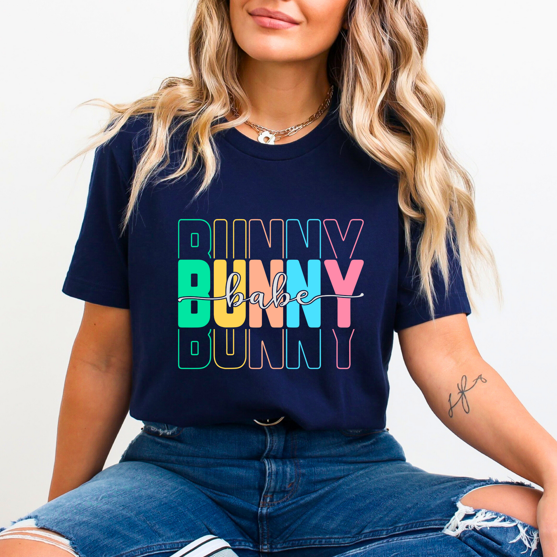 Trendy Bunny Babe graphic t-shirt with colorful pastel typography, perfect for Easter outfits, spring fashion, and casual wear. Soft cotton tee for women.