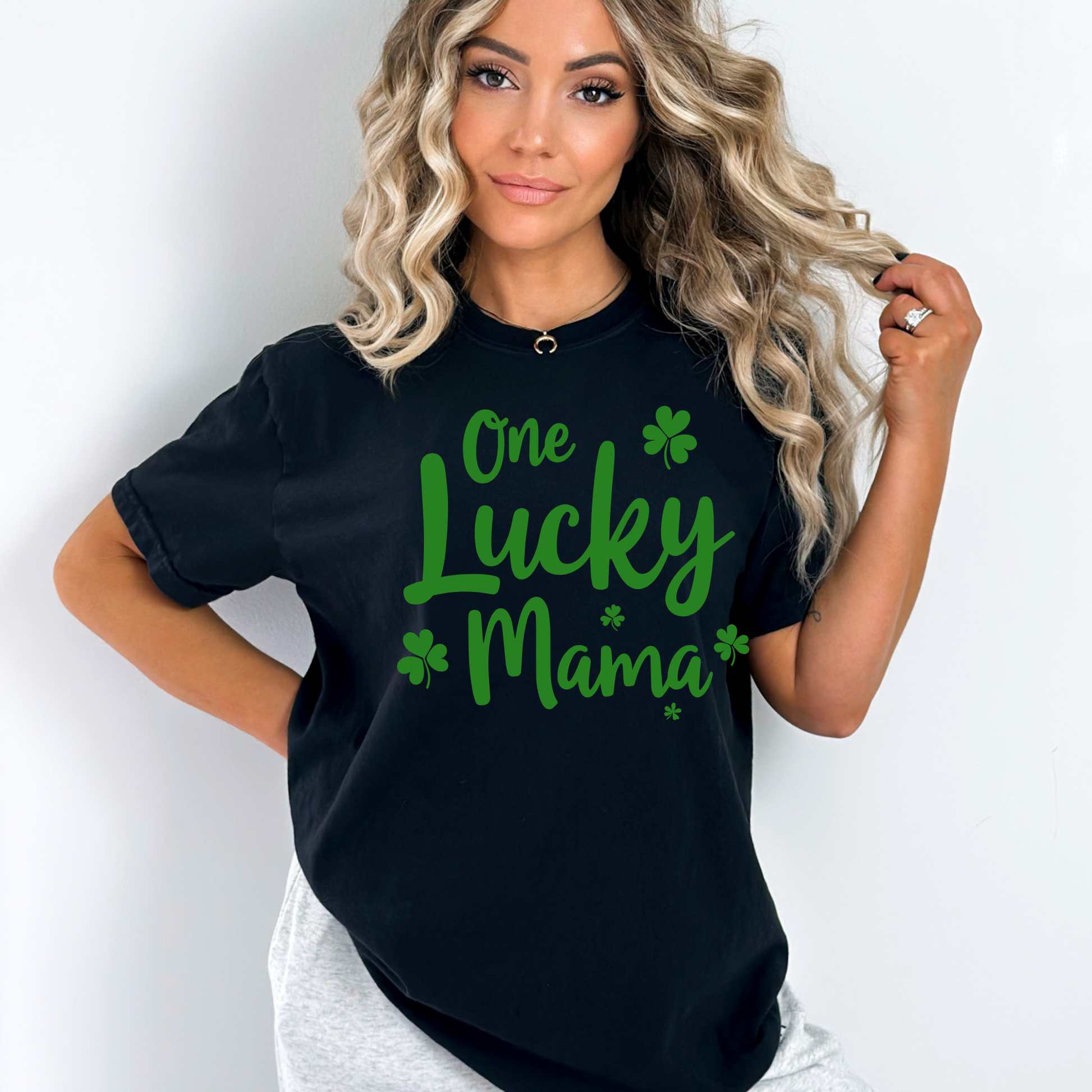 A stylish blue t-shirt with "One Lucky Mama" in green script, decorated with shamrocks. Perfect for moms celebrating St. Patrick’s Day in a cute and festive way.