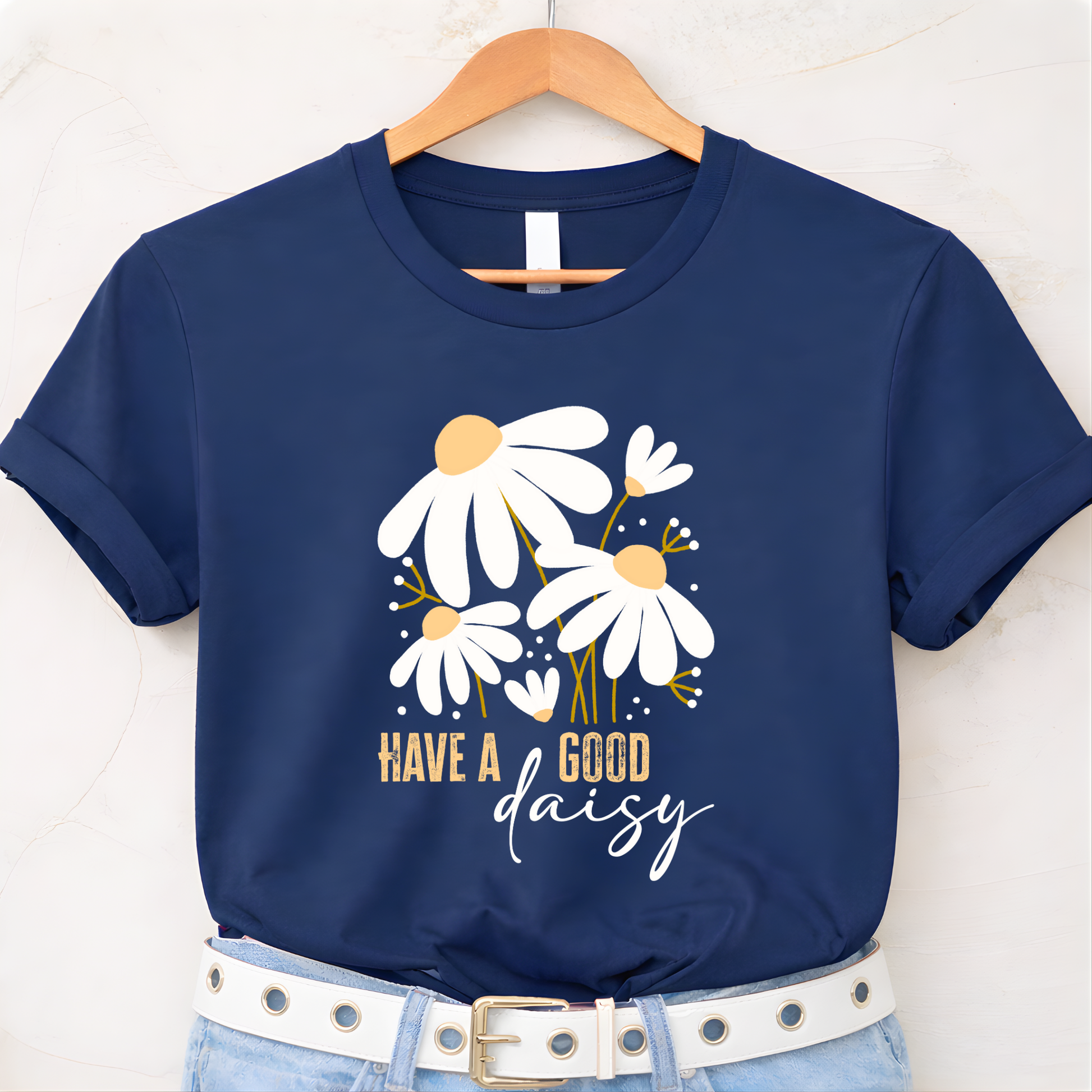 Navy blue t-shirt with floral design and text 'Have a good daisy' on a white background