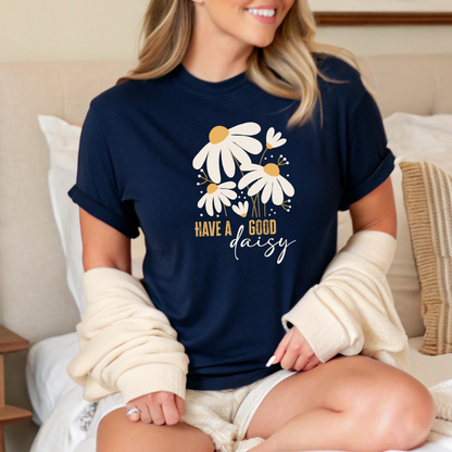 Woman wearing a navy blue t-shirt with floral design and text, sitting on a couch.