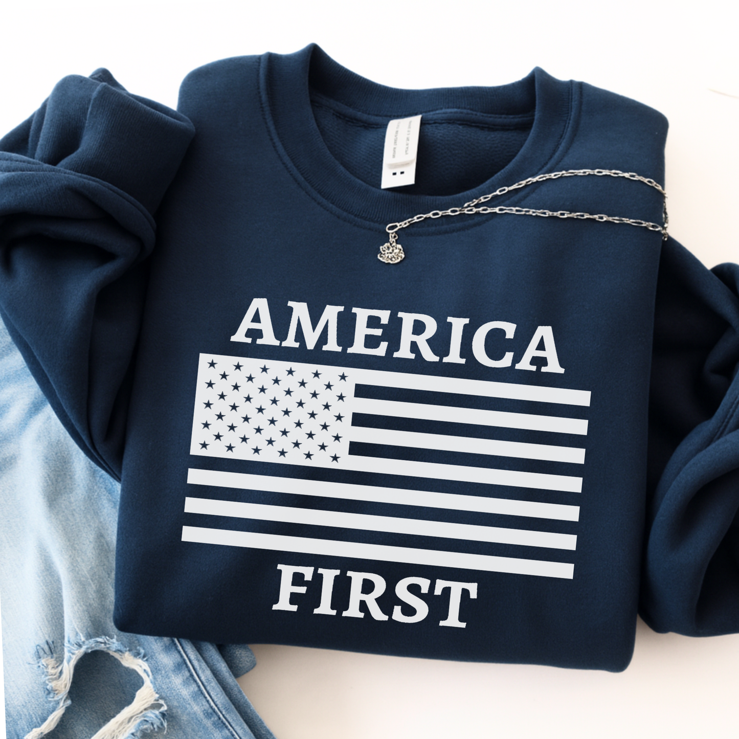 Navy blue sweatshirt with 'AMERICA FIRST' text and American flag design on a white background.