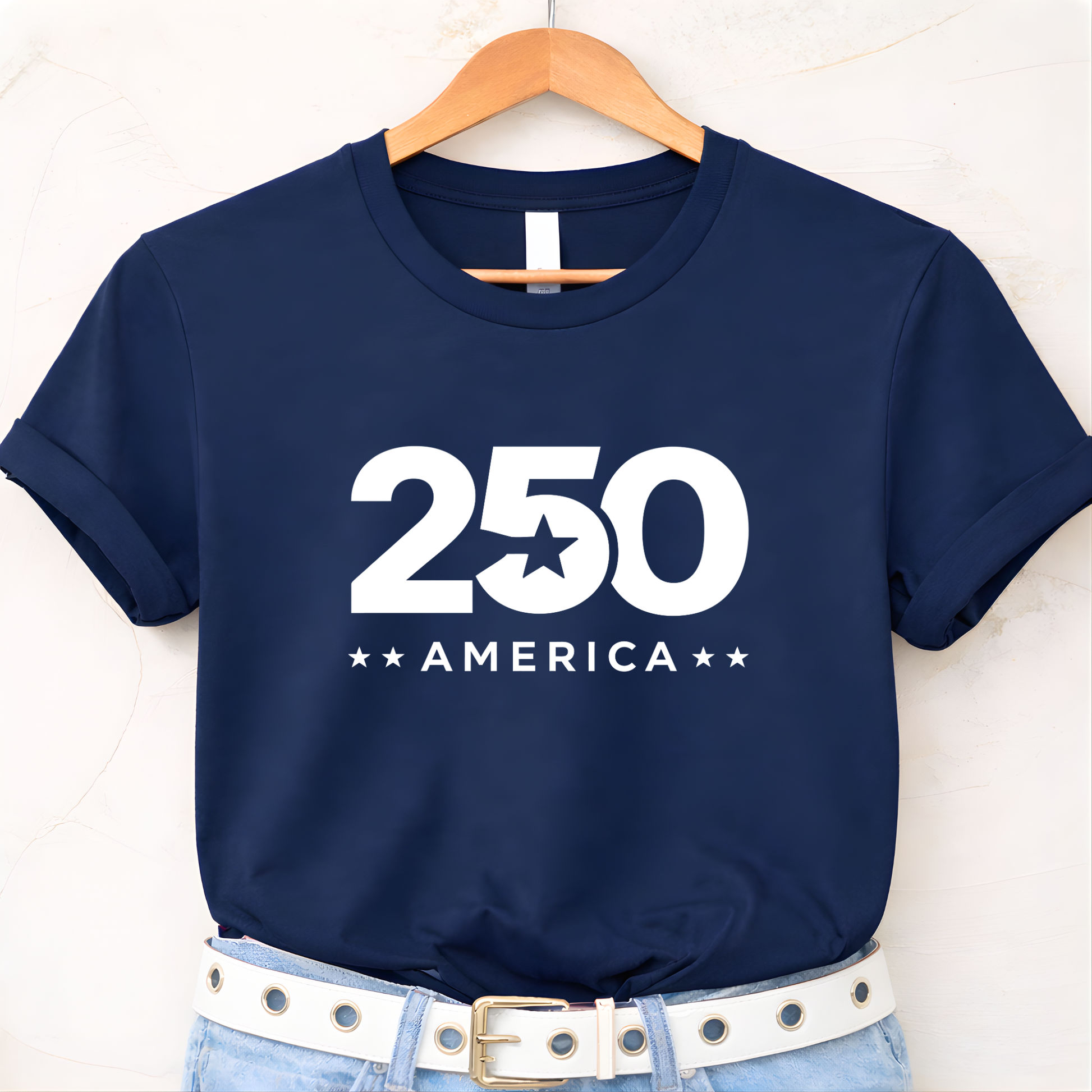 Navy blue t-shirt with '250 America' print on a hanger against a white background